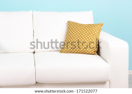 White sofa close-up in room on blue background
