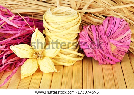 Decorative straw for hand made, flower and heart of straw, on wooden background