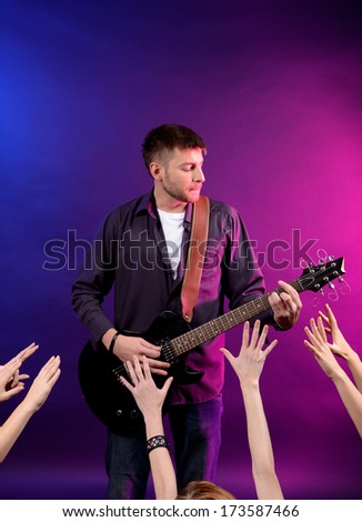 Guitarist singing on stage at a rock concert for his adoring fans