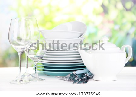 Clean dishes on table on natural background