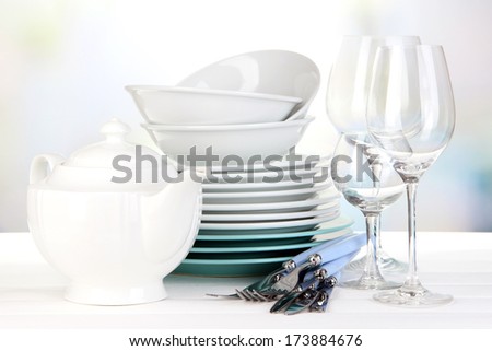 Clean dishes on table on bright background