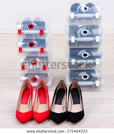 Shoes in plastic boxes and female shoes on floor in room