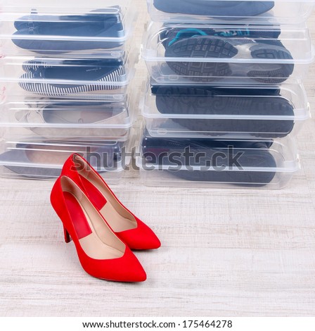 Shoes in plastic boxes and female shoes on floor in room