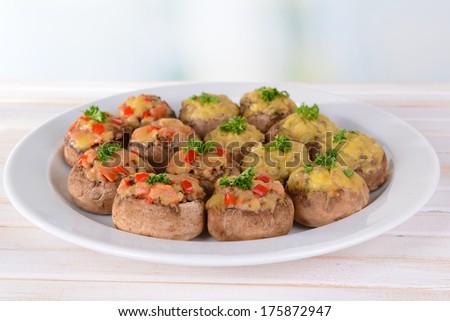 Stuffed mushrooms on plate on table on light background