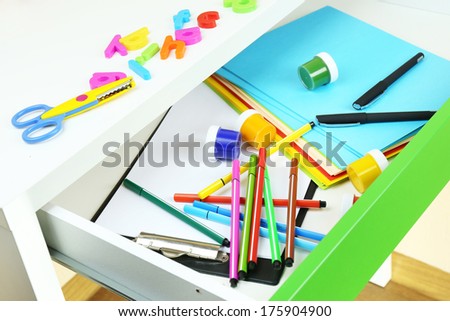 School supplies in open desk drawer close up