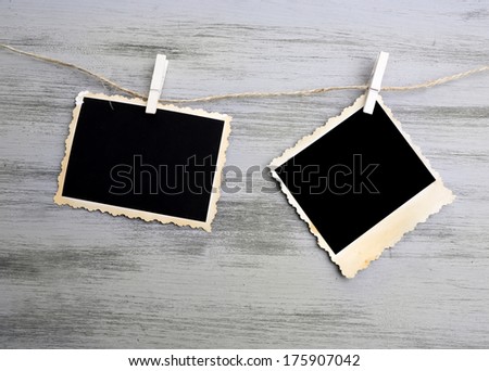 Blank old photos on rope on color wooden background