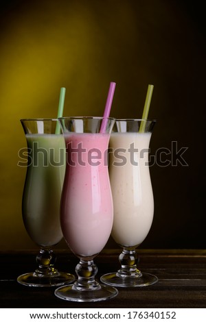 Milk shakes on table on dark yellow background