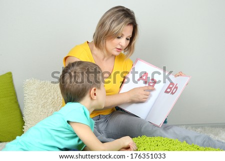 Little boy with mom read book in bed