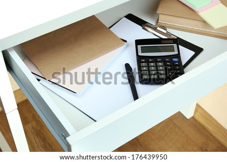 Office supplies in open desk drawer close up