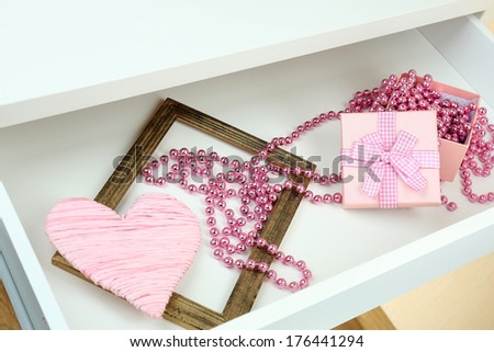 Gift box and beads in open desk drawer close up