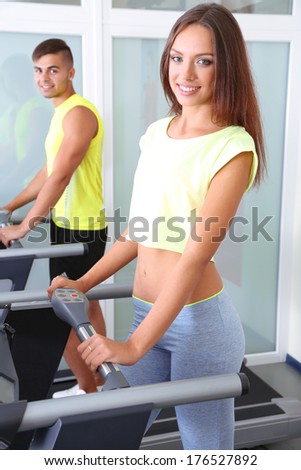 Guy and girl on treadmills at gym