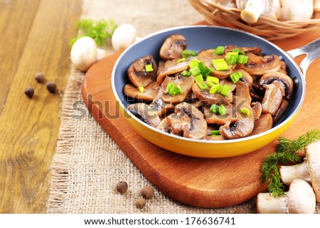 Delicious fried mushrooms in pan on table close-up