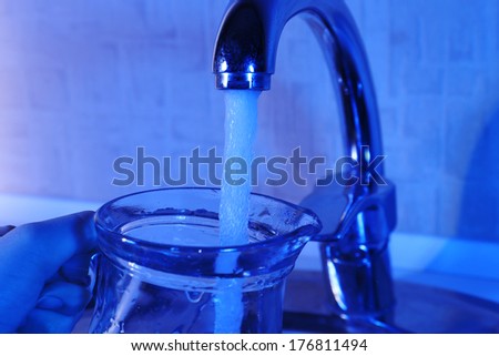 Filling up glass pitcher of water