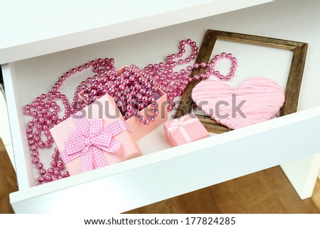 Gift box and beads in open desk drawer close up
