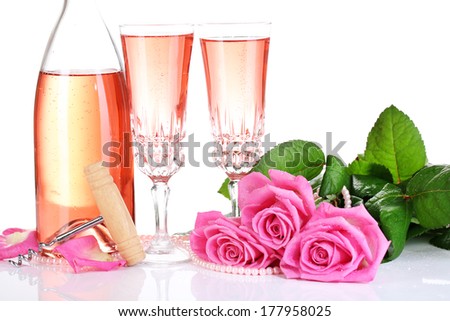 Composition with pink sparkle wine in glasses, bottle and pink roses isolated on white