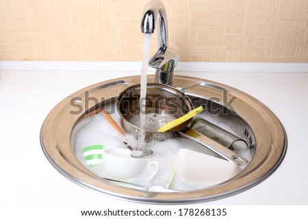 Utensils soaking in kitchen sink
