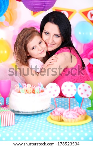 Pretty little girl with mom celebrate her birthday