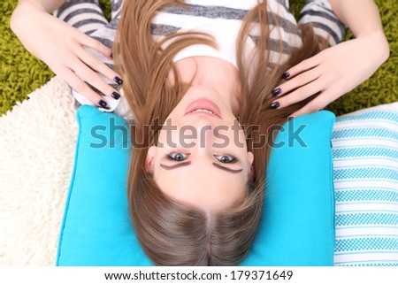 Young woman resting on fluffy carpet, close-up