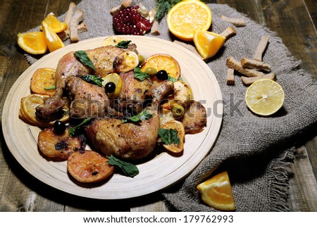 Homemade fried chicken drumsticks with vegetables on wooden tray, on wooden background
