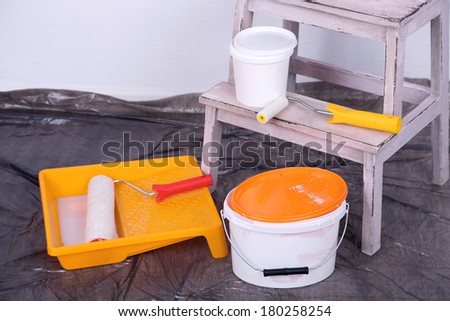Buckets with paint and ladder on wall background. Conceptual photo of repairing works in  room