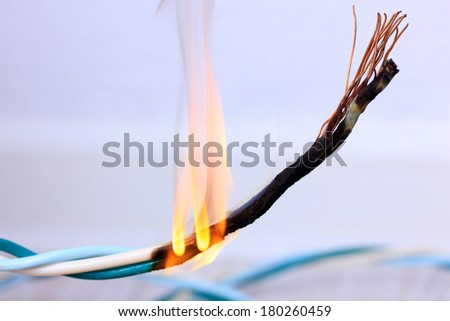 Short circuit, burnt cable, on color wooden background