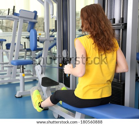 Young woman training with weights in gym