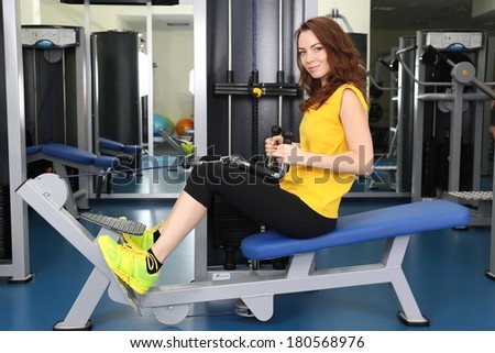 Young woman training with weights in gym