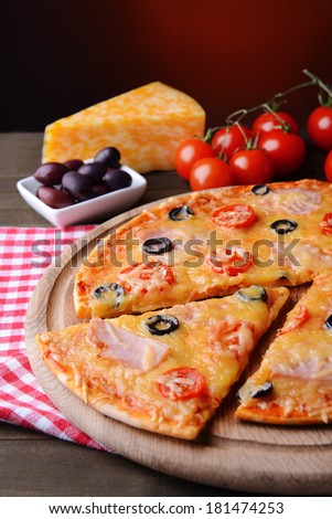 Tasty pizza on table on dark red background