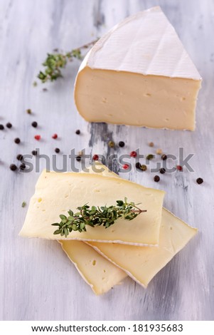 Tasty Camembert cheese with spices, on wooden table