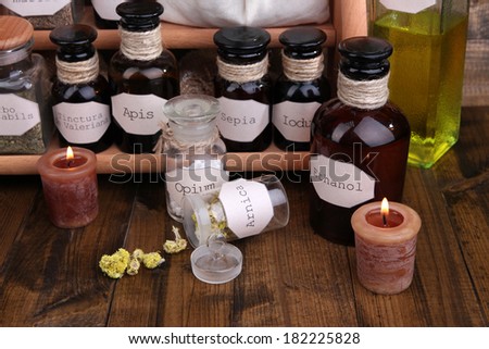 Composition with empty page, candle and historic old pharmacy bottles with label   on wooden background