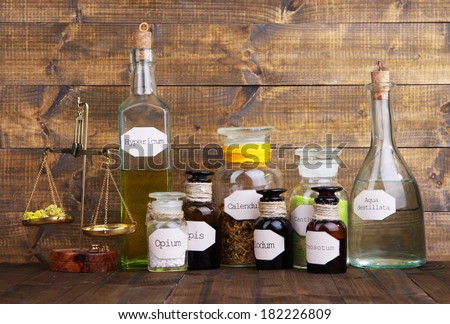 Historic old pharmacy bottles with label and Old-fashioned weight scales, on wooden background