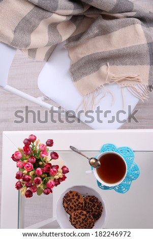 Composition with cup of hot drink, candle and flowers on wooden table background