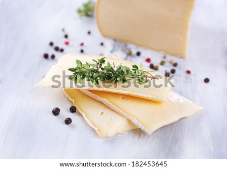 Tasty Camembert cheese with spices, on wooden table