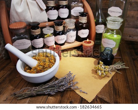 Composition with empty page, candle, mortar and historic old pharmacy bottles with label   on wooden background