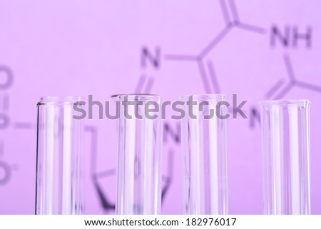 Test tube on written reaction formula background, close-up