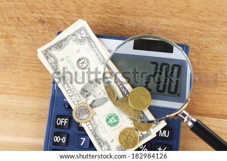 Fraud concept with magnifier and calculator, on wooden background