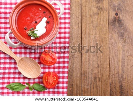 Tasty tomato soup on wooden table