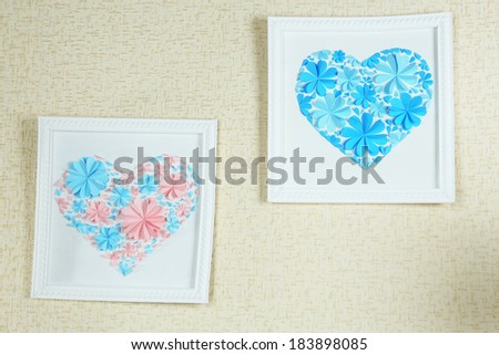 Beautiful handmade picture with heart from paper flowers on wall