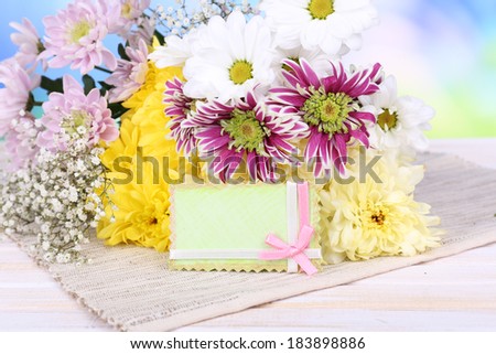 Beautiful chrysanthemum flowers on table on light blue background