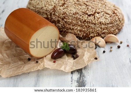 Tasty smoked cheese and bread on wooden table