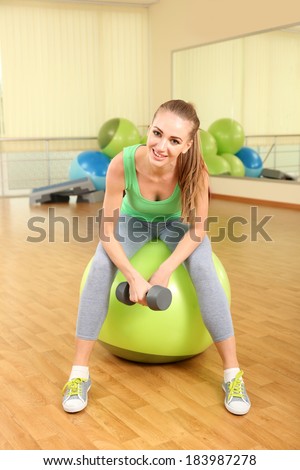 Young woman with gymnastic ball in gym