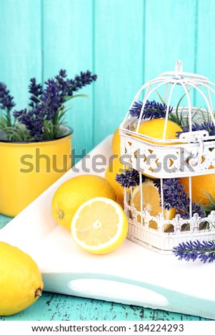 Still life with fresh lemons and lavender on blue background