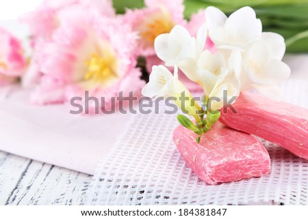 Composition with beautiful  flowers and soap on wooden background