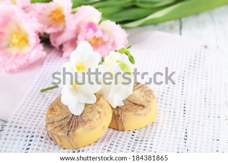 Composition with beautiful  flowers and soap on wooden background