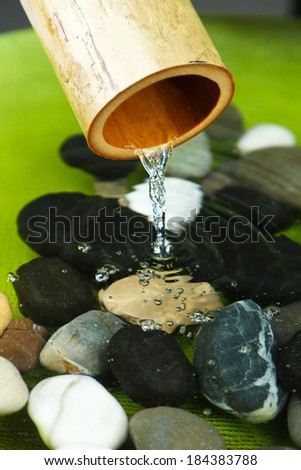 Spa still life with bamboo fountain and stones, close up
