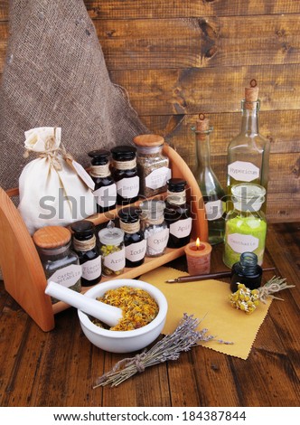 Composition with empty page, candle, mortar and historic old pharmacy bottles with label   on wooden background