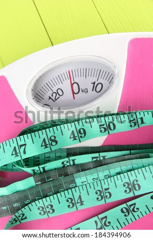 Measuring tape and scales close-up on wooden table