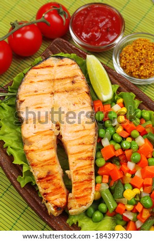 Tasty grilled salmon with vegetables, on bamboo mat