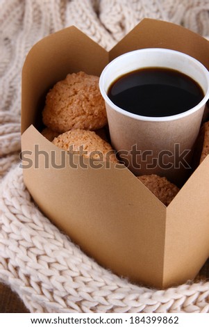 Hot coffee and cookies in box on knitted scarf  close-up
