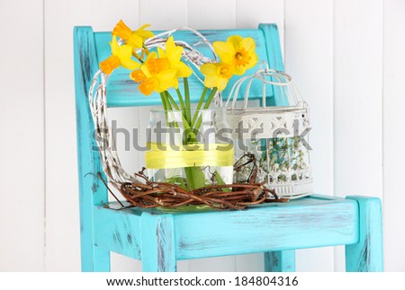 Beautiful spring flowers on blue old wooden chair